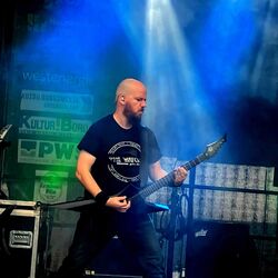 Gitarrist spielt konzentriert mit stimmungsvoller Lichtreflexion bei Rock im Onnergrond
