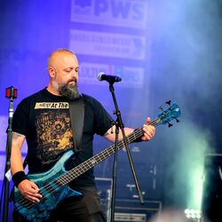 Bassist spielt blaue E-Bassgitarre am Mikrofon bei Rock im Onnergrond