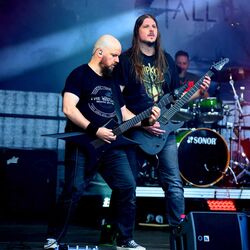 Zwei Gitarristen von Miles2Fall spielen nebeneinander im blauen Buehnenlicht beim Festival Rock im Onnergrond