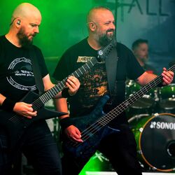 Zwei Musiker von Miles2Fall spielen Gitarre im gruenen Buehnenlicht beim Festival Rock im Onnergrond