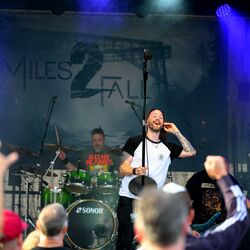 Gesamtansicht der Band auf der Bühne mit begeistertem Publikum bei Rock im Onnergrond