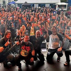 Die Band Miles2Fall posiert gemeinsam mit jubelnden Fans vor der Bühne beim Festival Rock im Onnergrond