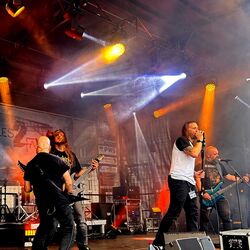 Band spielt live vor bunter Bühnenbeleuchtung bei Rock im Onnergrond